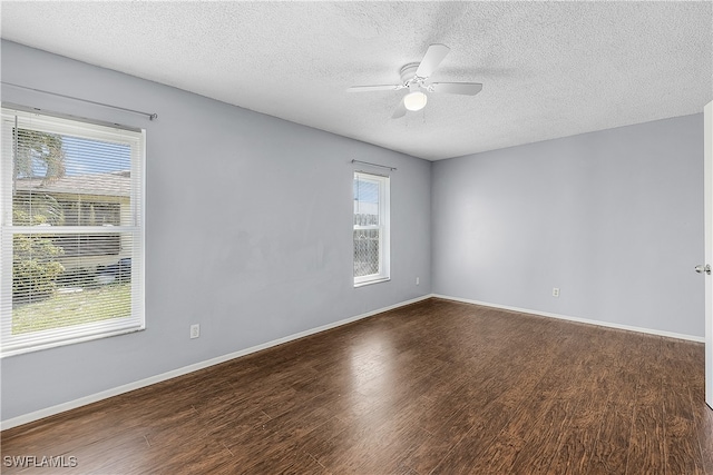 empty room featuring a textured ceiling, a healthy amount of sunlight, ceiling fan, and hardwood / wood-style flooring