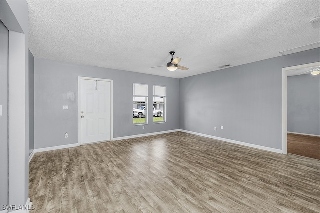 empty room featuring a textured ceiling, ceiling fan, and hardwood / wood-style flooring