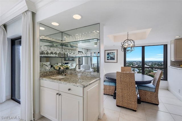 bar featuring a tray ceiling, indoor wet bar, light tile patterned floors, recessed lighting, and a sink