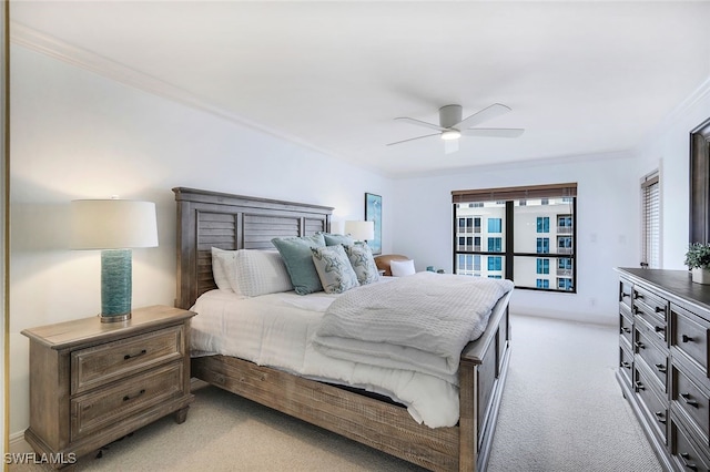 bedroom with ornamental molding, light carpet, and a ceiling fan