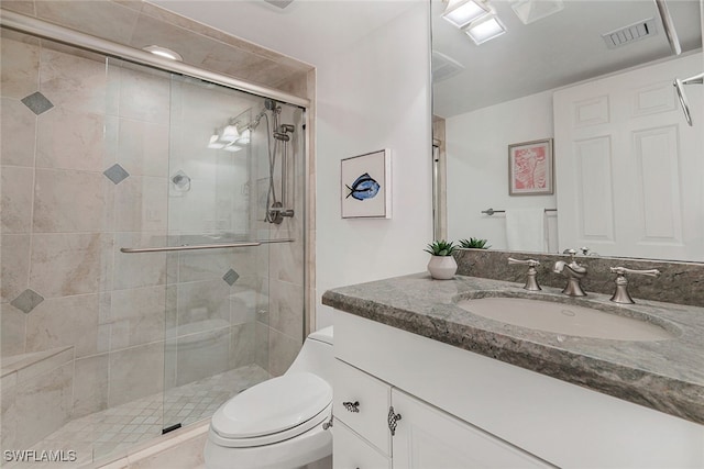 bathroom with toilet, a shower stall, visible vents, and vanity