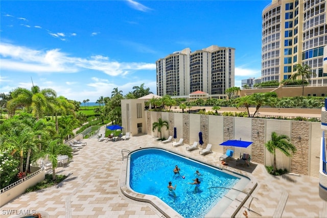 community pool with a patio area and a city view