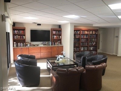 carpeted living room with a paneled ceiling