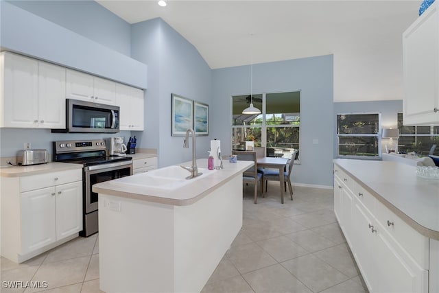 kitchen with hanging light fixtures, appliances with stainless steel finishes, white cabinetry, and a kitchen island with sink