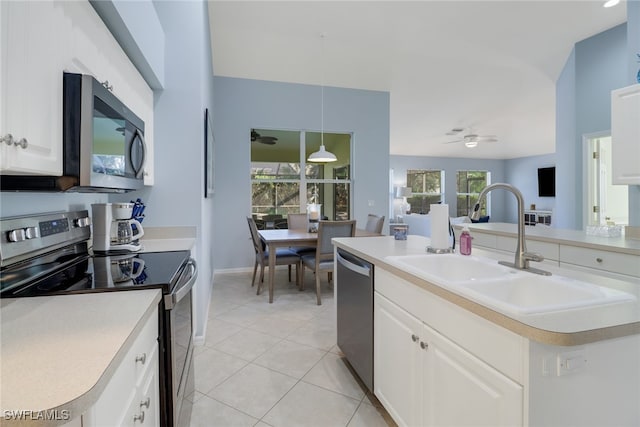 kitchen featuring an island with sink, plenty of natural light, stainless steel appliances, and white cabinets