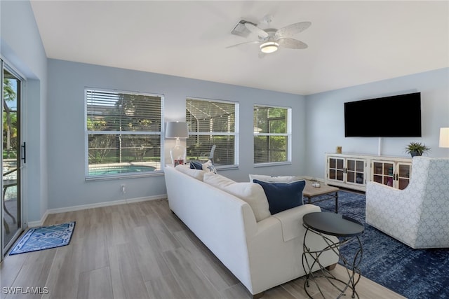 living room featuring plenty of natural light, ceiling fan, and wood-type flooring