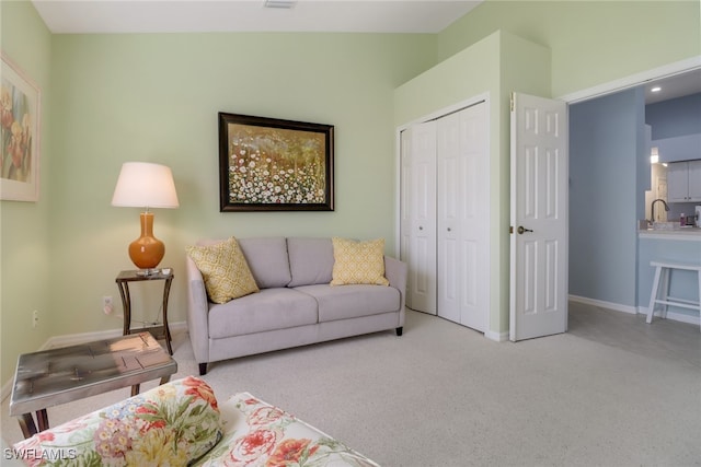 living room featuring light colored carpet, vaulted ceiling, and sink