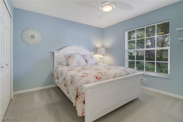 carpeted bedroom featuring ceiling fan, a closet, and multiple windows