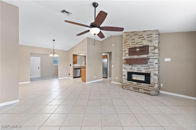 unfurnished living room featuring ceiling fan with notable chandelier, high vaulted ceiling, light tile patterned floors, and a stone fireplace