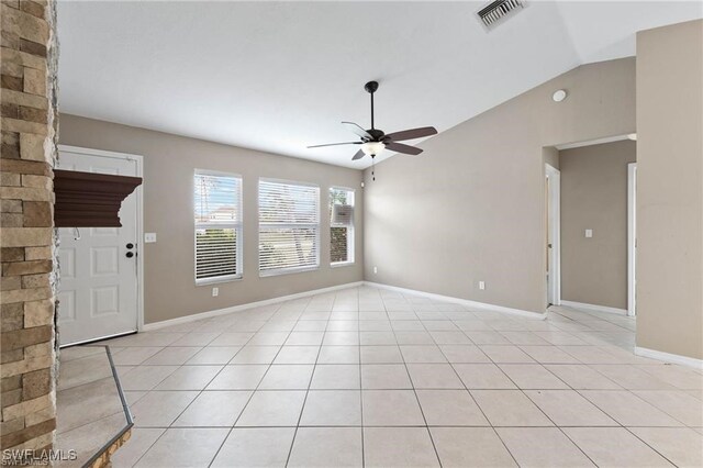 empty room with vaulted ceiling, light tile patterned flooring, and ceiling fan