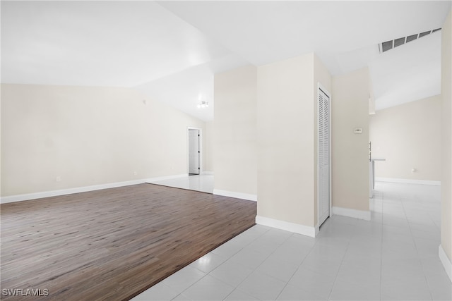 tiled empty room with lofted ceiling