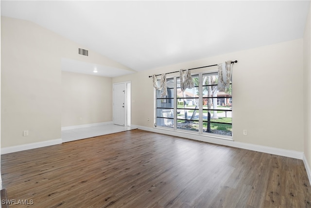 unfurnished room with dark hardwood / wood-style floors and lofted ceiling