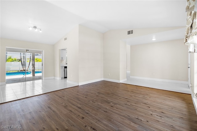 unfurnished room with lofted ceiling and hardwood / wood-style flooring