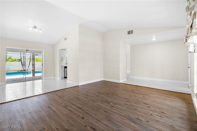 empty room featuring lofted ceiling and hardwood / wood-style floors