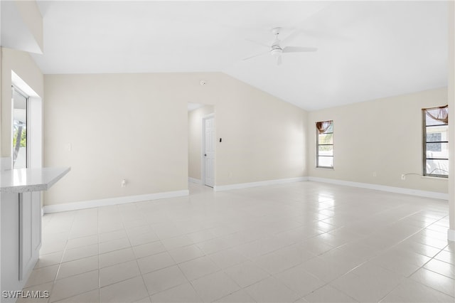 unfurnished living room featuring ceiling fan, vaulted ceiling, and light tile patterned flooring