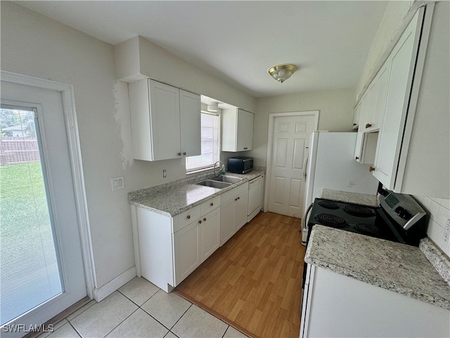 kitchen with black range with electric stovetop, plenty of natural light, sink, and light hardwood / wood-style flooring