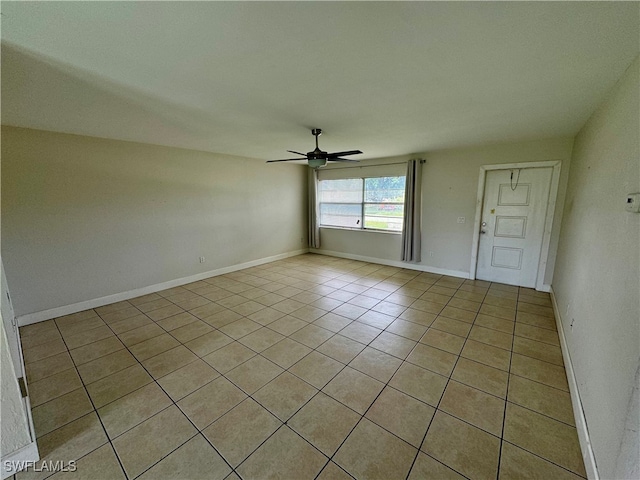 empty room with ceiling fan and light tile patterned flooring