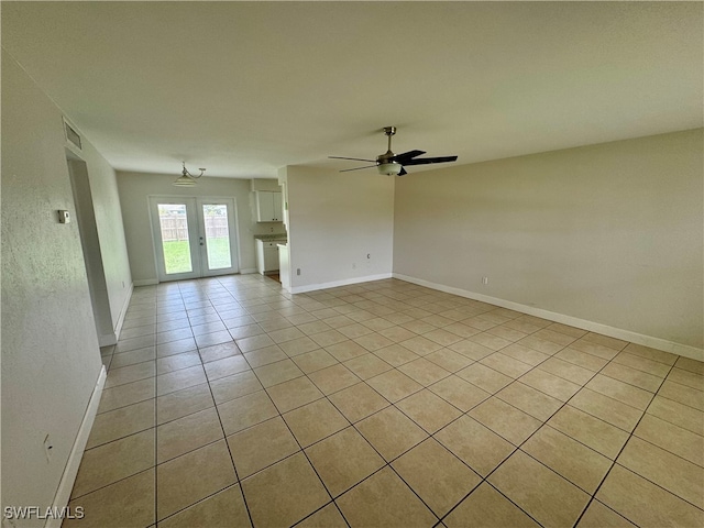 tiled spare room with ceiling fan and french doors