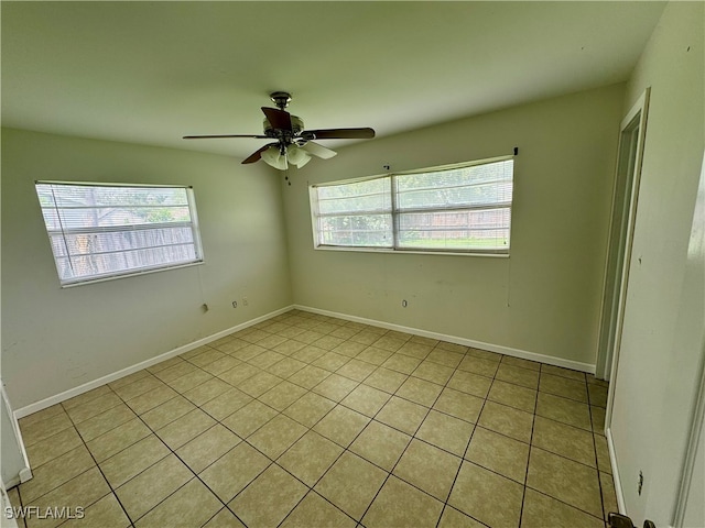 tiled empty room featuring ceiling fan and a healthy amount of sunlight