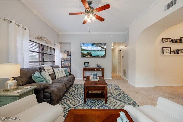 living area featuring arched walkways, visible vents, crown molding, and light tile patterned flooring