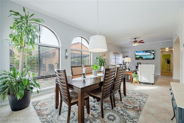 tiled dining room with crown molding and ceiling fan