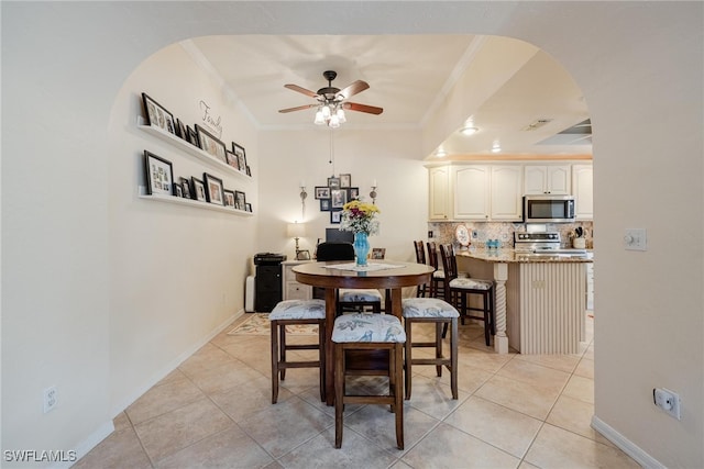 dining space featuring ceiling fan, ornamental molding, and light tile patterned floors