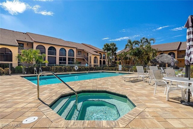 view of pool featuring a community hot tub and a patio area