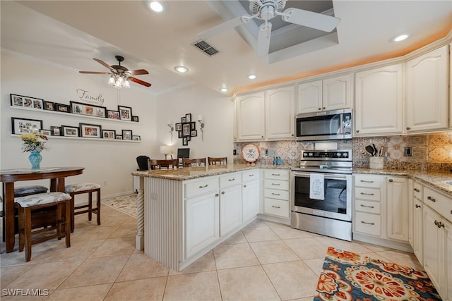 kitchen with light stone countertops, crown molding, stainless steel appliances, kitchen peninsula, and ceiling fan