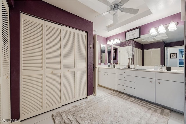 bathroom with tile patterned floors, a tray ceiling, ceiling fan, and vanity