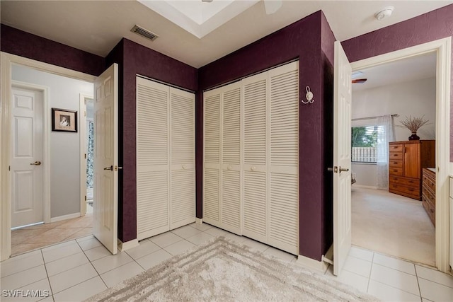 unfurnished bedroom featuring light tile patterned flooring, visible vents, and baseboards