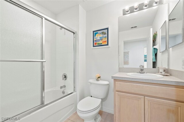 full bathroom featuring tile patterned flooring, vanity, toilet, and enclosed tub / shower combo