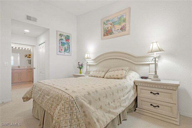 carpeted bedroom with a closet and ensuite bathroom