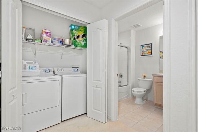 laundry room featuring light tile patterned floors and washing machine and dryer