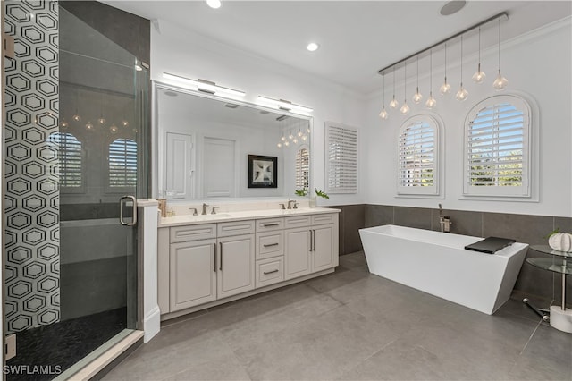 bathroom featuring crown molding, vanity, tile walls, and separate shower and tub