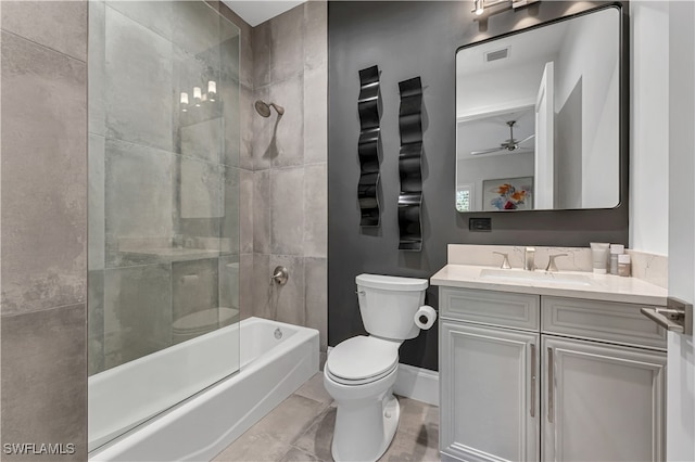 full bathroom with ceiling fan, toilet, tiled shower / bath combo, and vanity