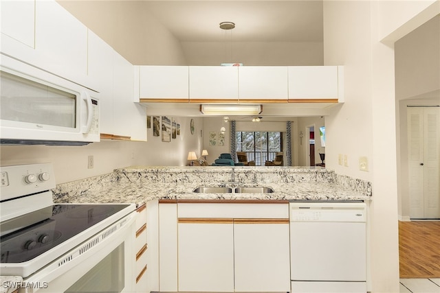 kitchen featuring light stone countertops, white appliances, light hardwood / wood-style floors, sink, and white cabinetry