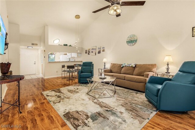 living room featuring ceiling fan, hardwood / wood-style floors, and high vaulted ceiling