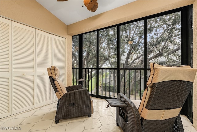 sunroom / solarium with vaulted ceiling, a healthy amount of sunlight, and ceiling fan