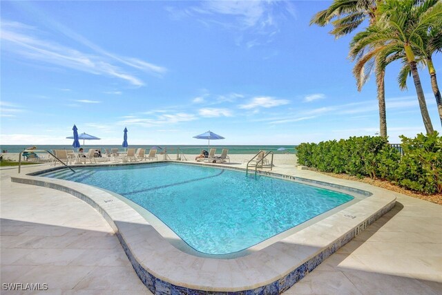 view of pool featuring a patio and a water view