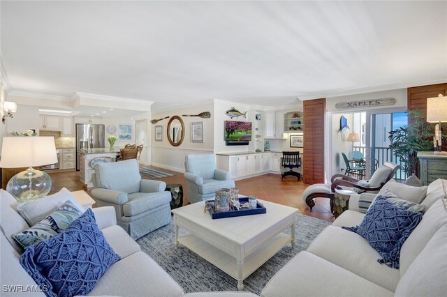 living room with ornamental molding, light tile patterned flooring, and an inviting chandelier