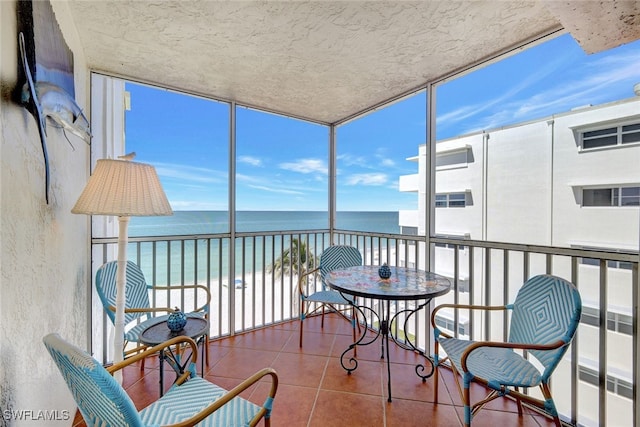 sunroom / solarium with a water view and a healthy amount of sunlight