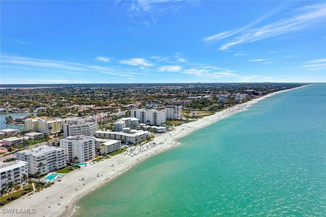 drone / aerial view featuring a water view, a beach view, and a city view