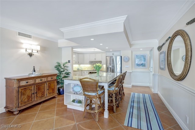 dining area featuring visible vents, wainscoting, light tile patterned flooring, crown molding, and recessed lighting