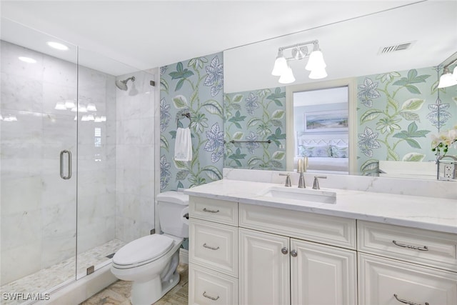 bathroom featuring vanity, a shower stall, toilet, and wallpapered walls