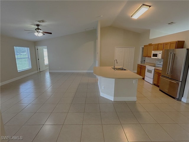 kitchen with lofted ceiling, an island with sink, sink, light tile patterned floors, and white appliances