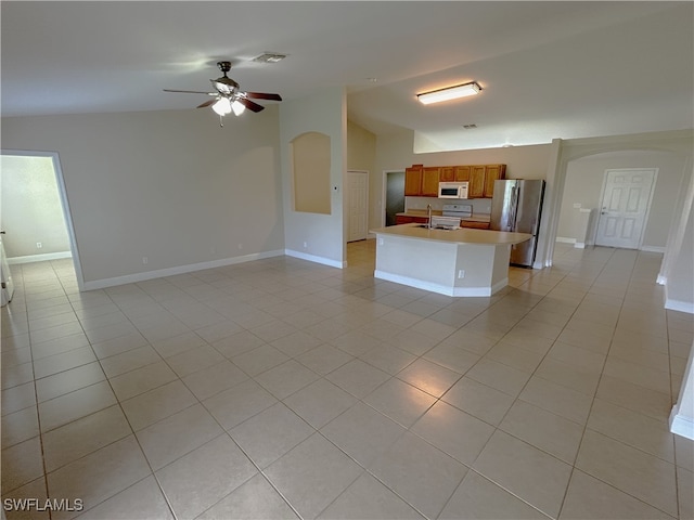 kitchen with lofted ceiling, sink, light tile patterned floors, white appliances, and ceiling fan