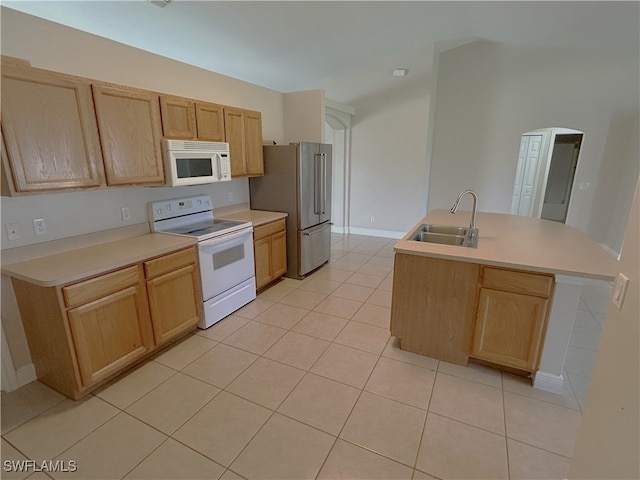 kitchen with light tile patterned flooring, light brown cabinets, sink, and white appliances