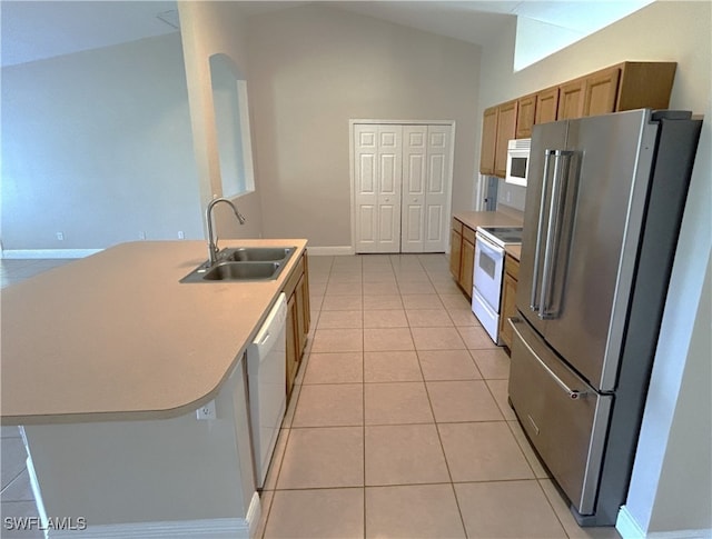 kitchen with a center island with sink, sink, vaulted ceiling, light tile patterned floors, and white appliances