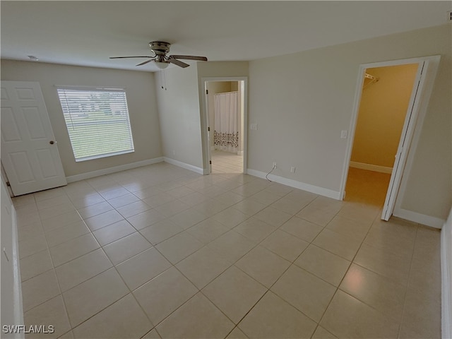 empty room featuring ceiling fan and light tile patterned floors