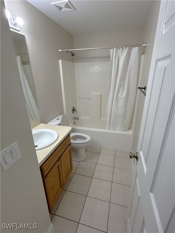 full bathroom featuring toilet, shower / bath combo, vanity, and tile patterned flooring